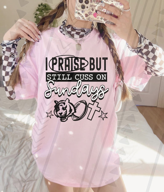 I Praise But Still Cuss On Sundays Football Shirt – Edgy Christian Sports Graphic Tee – Unisex DTF Print – Youth & Adult Sizes